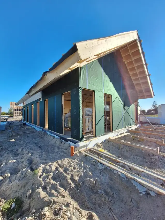 Timber house under construction with the walls wrapped before cladding