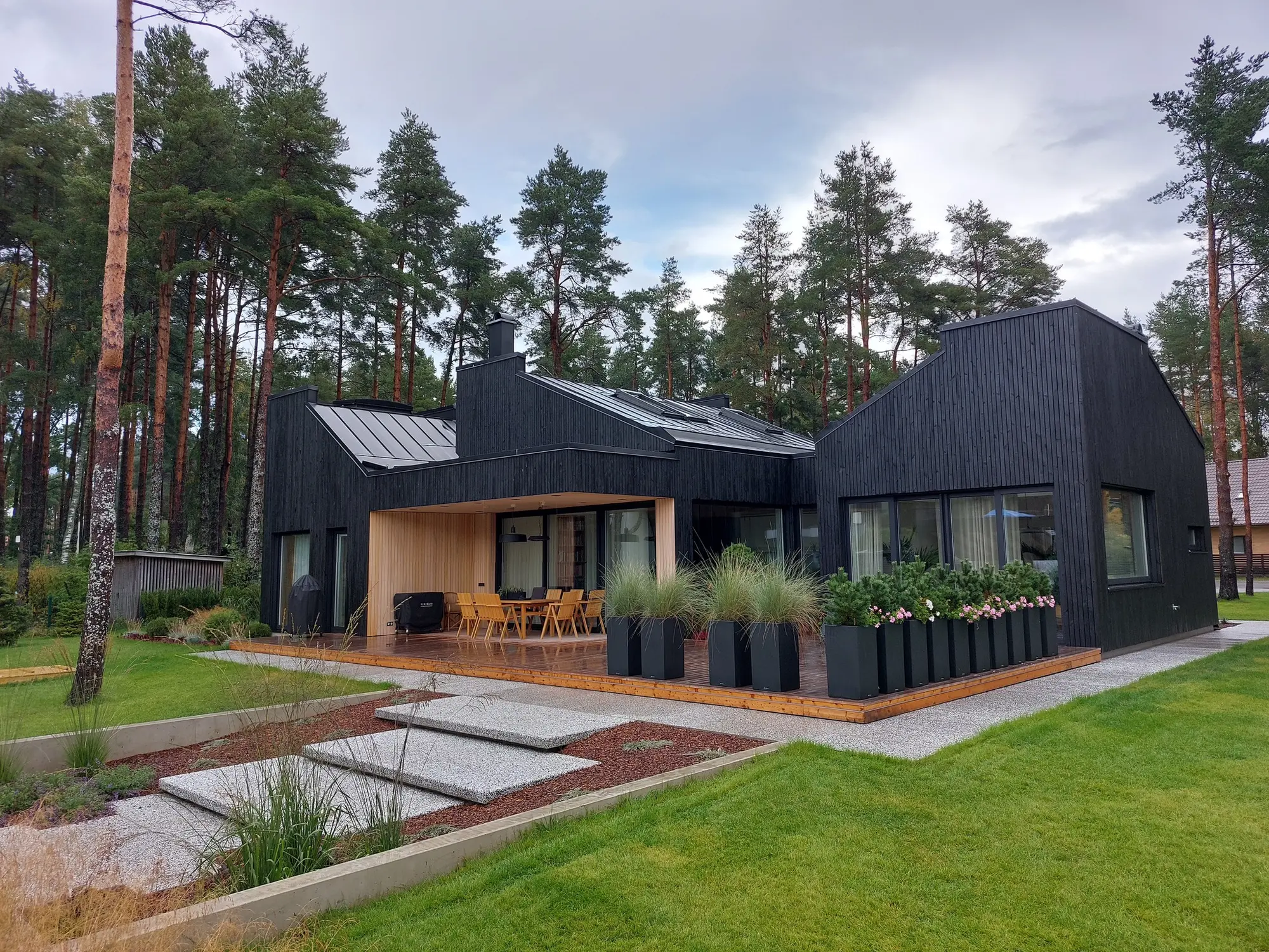 Finished black timber house among pine trees