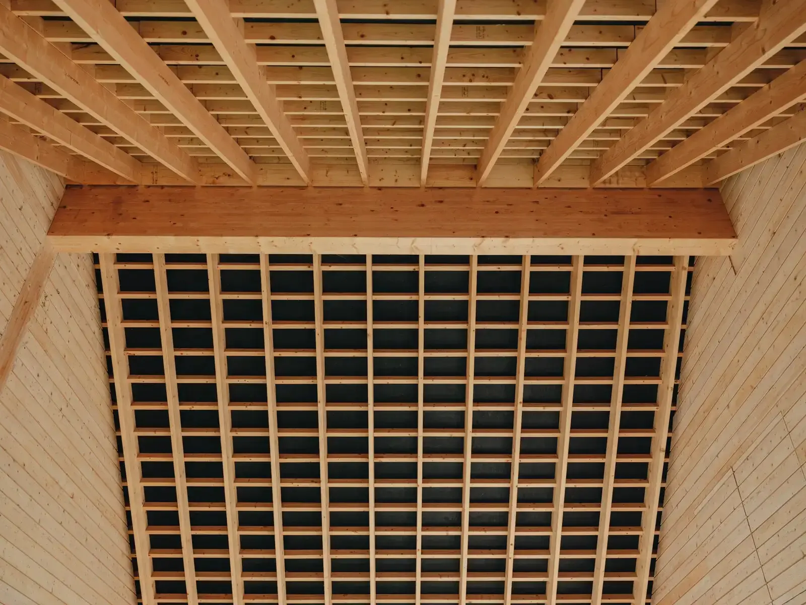 Closely spaced timber joists and a slatted screen forming the ceiling of an interior