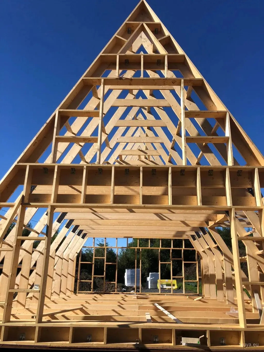 Timber A-frame frame raised against a blue sky during construction